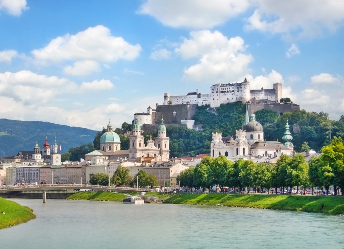 Skyline von Salzburg mit Fluss im Vordergrund.