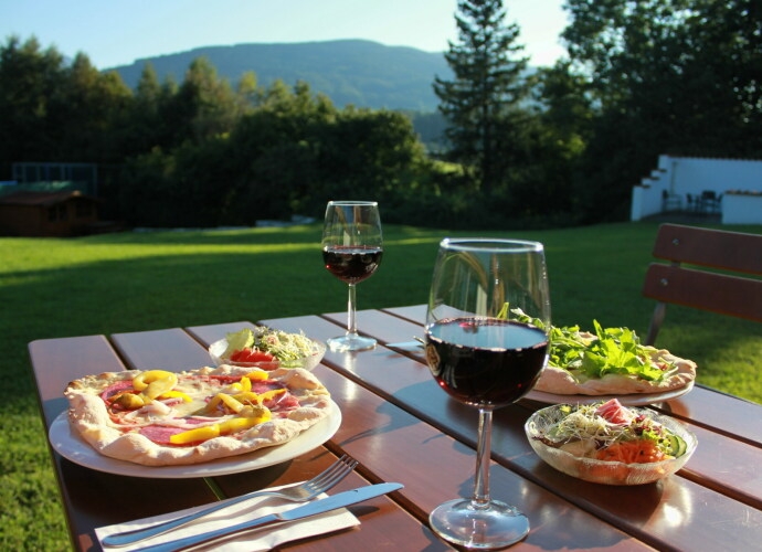 Tisch auf der Terrasse im Haus Chiemgau, serviert mit Pizza und Salat.