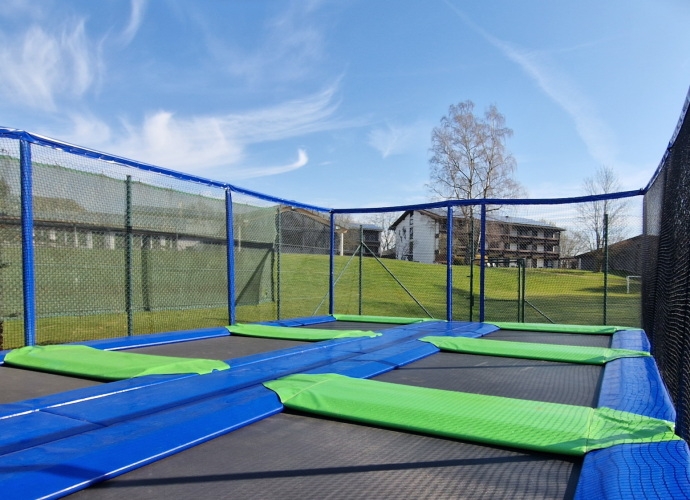 Sechsfeld-Trampolin im Außenbereich, auf dem Kinder hüpfen können